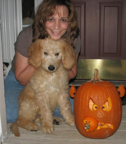 Jennifer and Moose posing with a halloween jack o' lantern. 